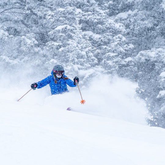 Skier at Bridger Bowl skiing powder and using Mtn Straps ski pole straps. 